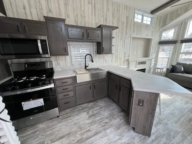 A kitchen in a mobile home with stainless steel appliances and a sink.