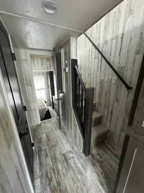 A hallway with stairs leading up to the second floor of a house.