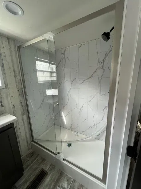 A bathroom with a walk in shower and a bathtub.