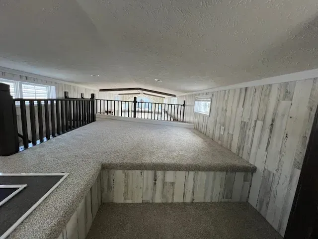 There is a bed in the middle of the room with a railing.
