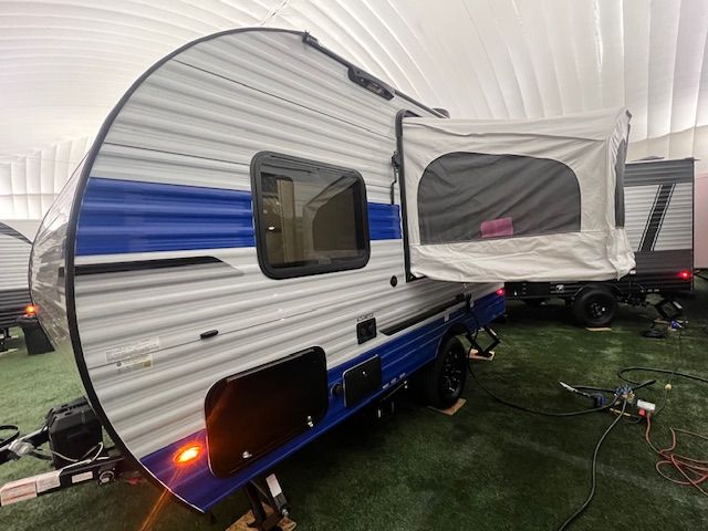A blue and white trailer is parked in a warehouse.