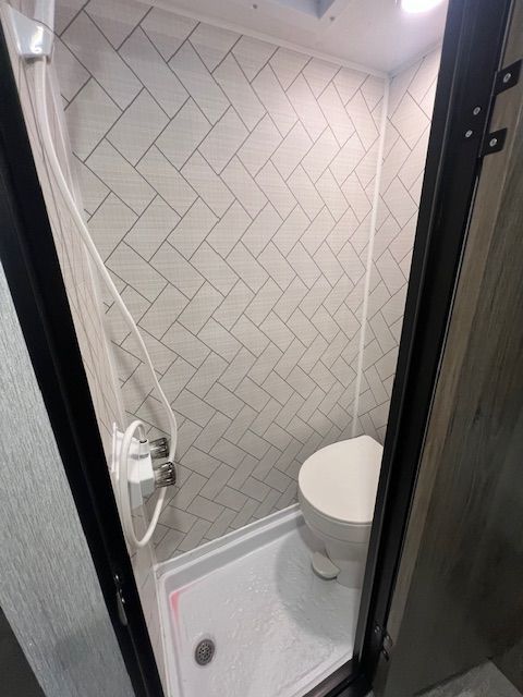 A bathroom with a toilet and a shower stall.