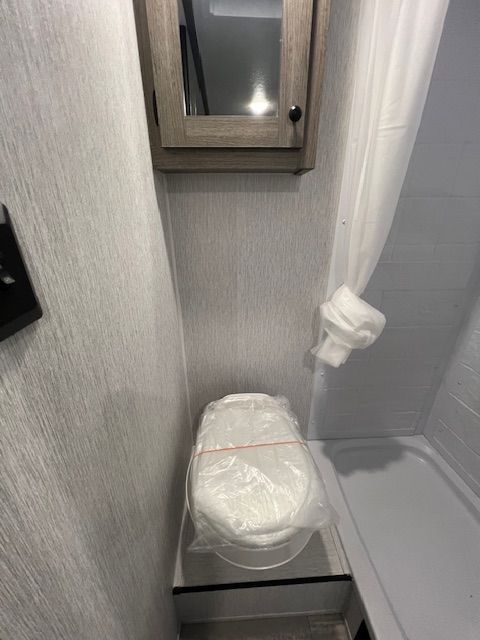 A bathroom with a toilet and a mirror.