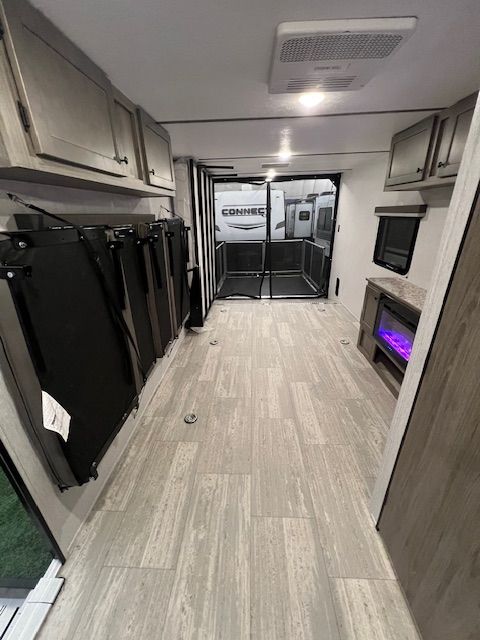 The inside of an RV with a sliding glass door and a fireplace.