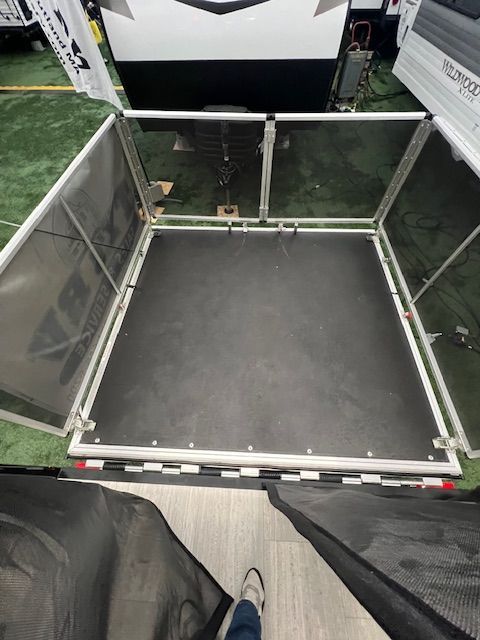 A person is standing in front of a trailer with a screen on it.