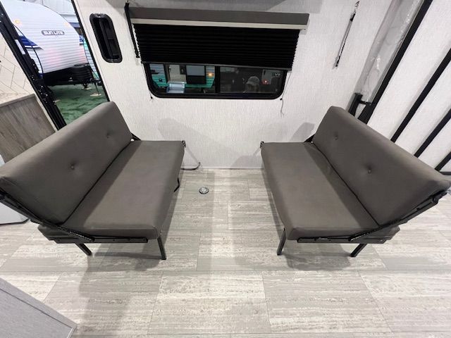 An RV with two couches and a window.