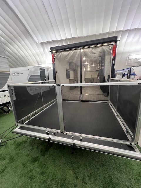 A trailer is parked in a warehouse with a screen door.