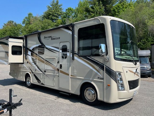 A large white RV is parked in a parking lot.