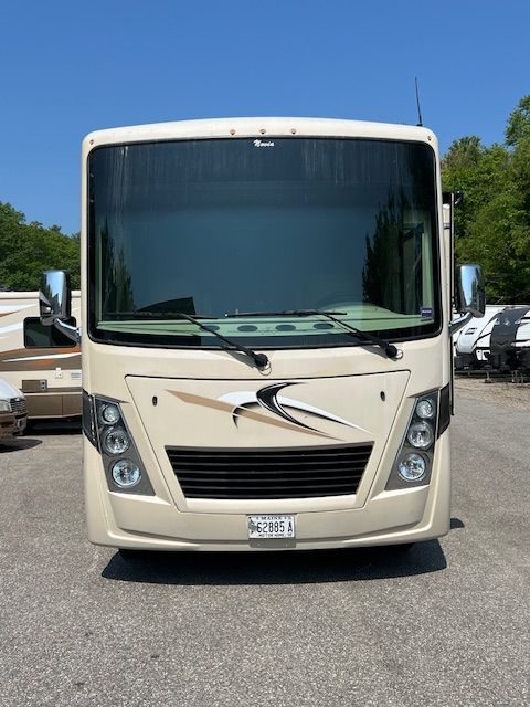 A large white RV is parked in a parking lot.