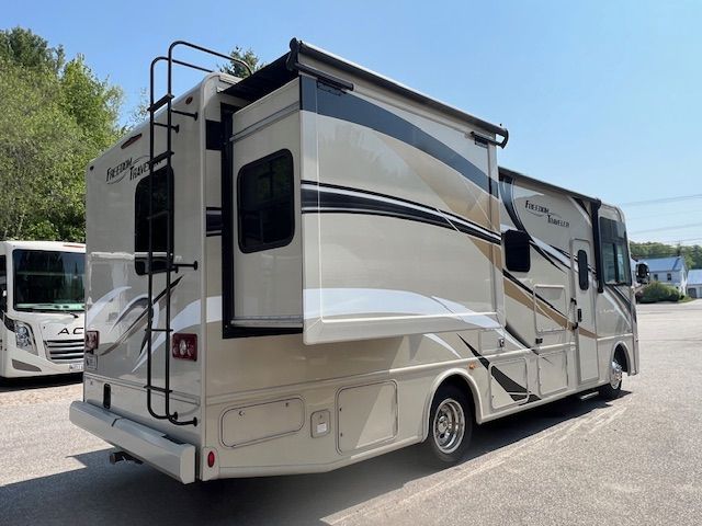 A large white RV is parked in a parking lot.