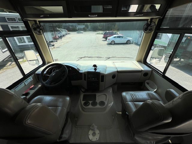 The inside of an RV with a steering wheel and seats