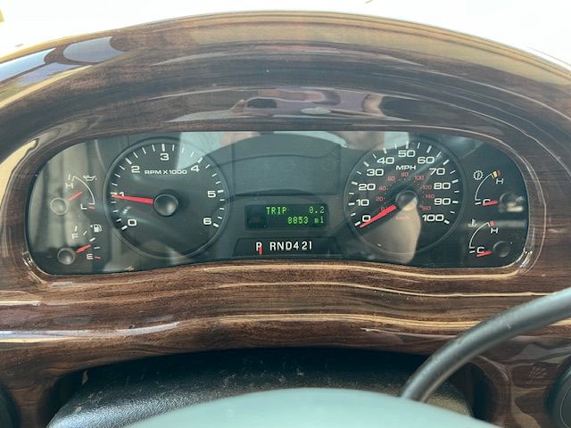 A close-up of a car dashboard with a wooden steering wheel.