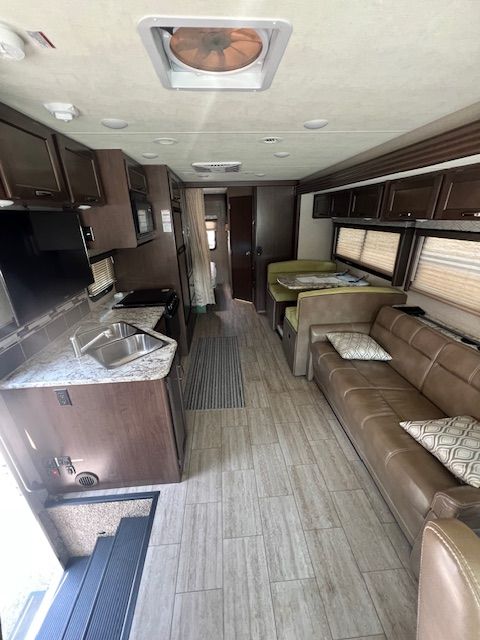 The inside of an RV with a couch and a kitchen.