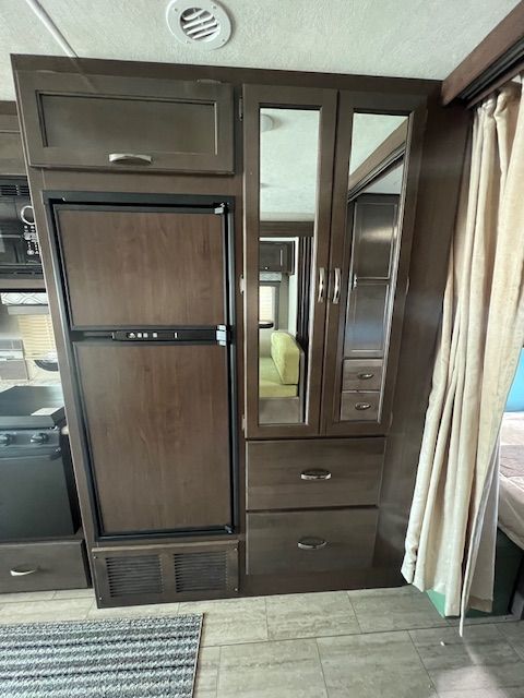 An RV with a refrigerator and drawers in it