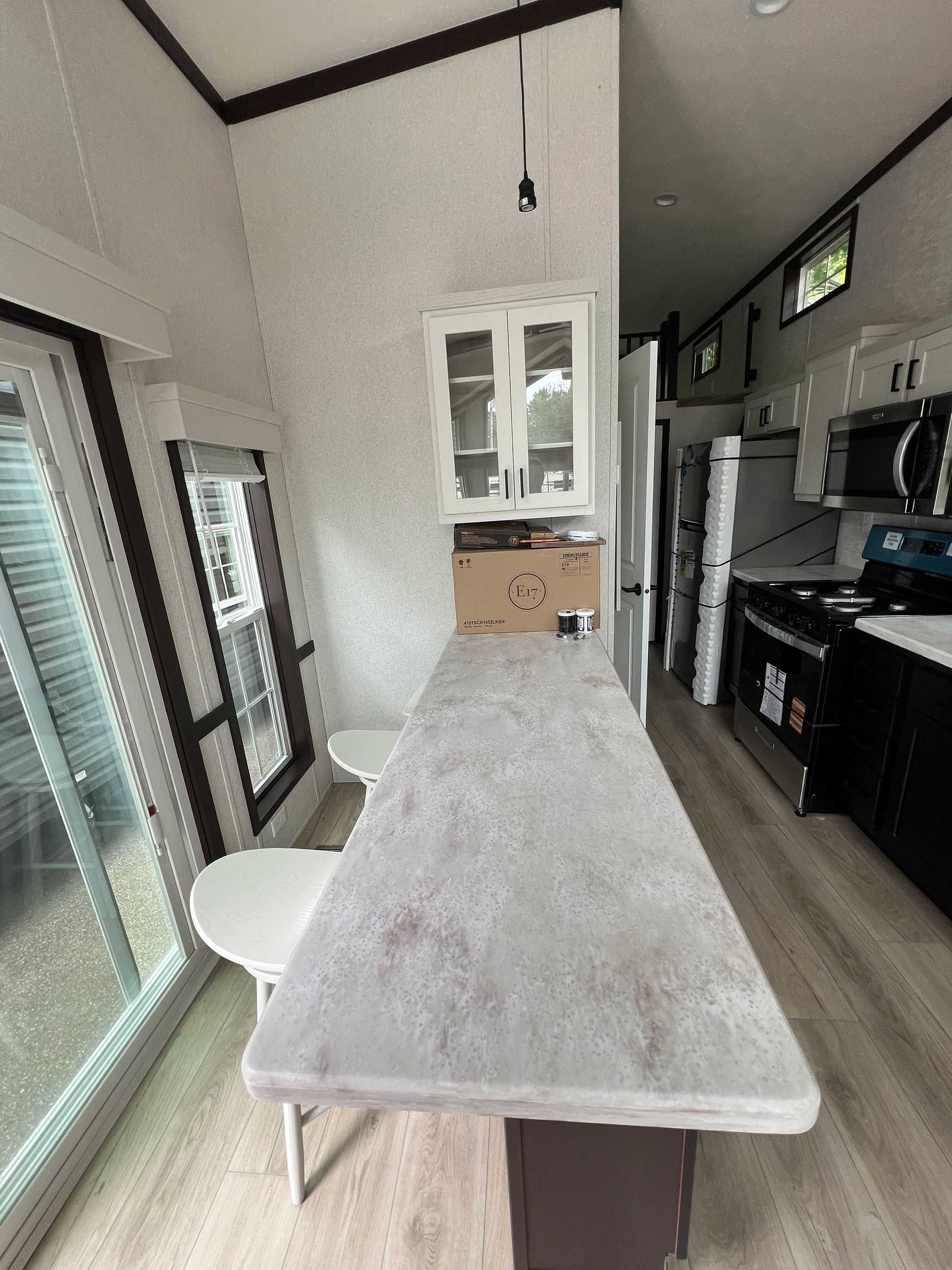 interior view of a kitchen with a long countertop, cabinets, and appliances