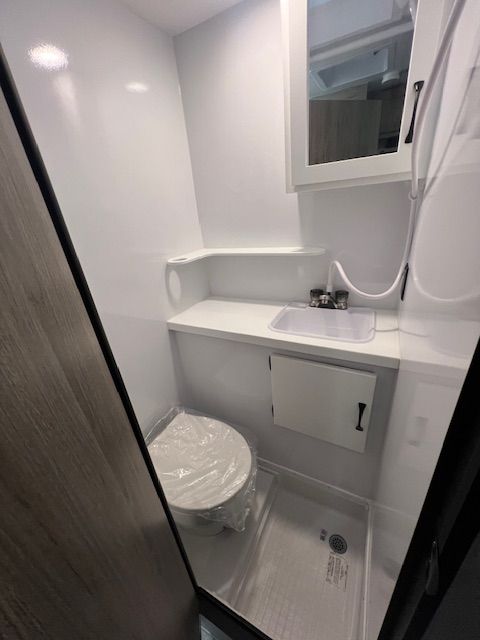 A bathroom with a toilet, sink and mirror
