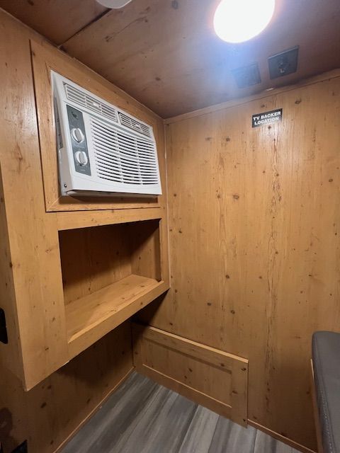 A room with a window air conditioner on the wall