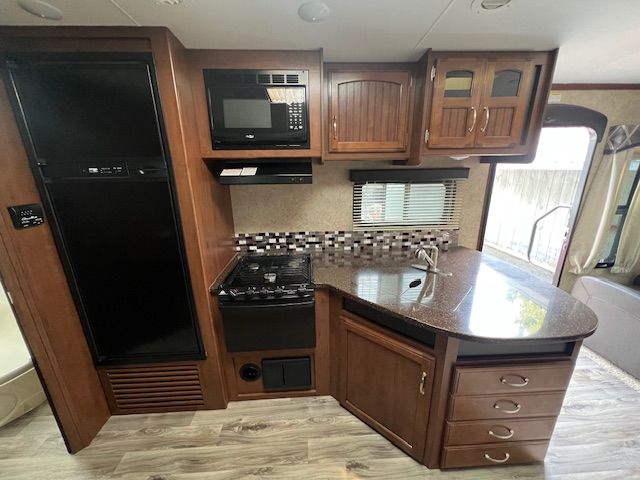 A kitchen with wooden cabinets and a granite counter top