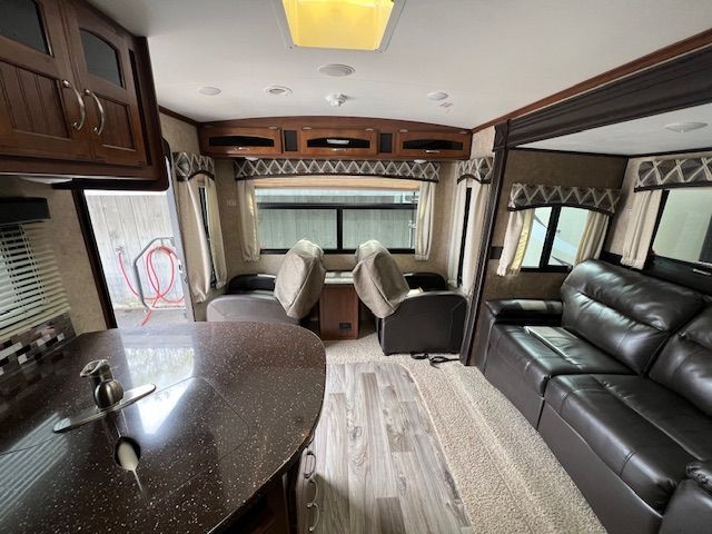 The inside of a RV with a couch and chairs