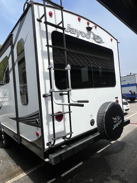 A white Jayco trailer is parked in a parking lot