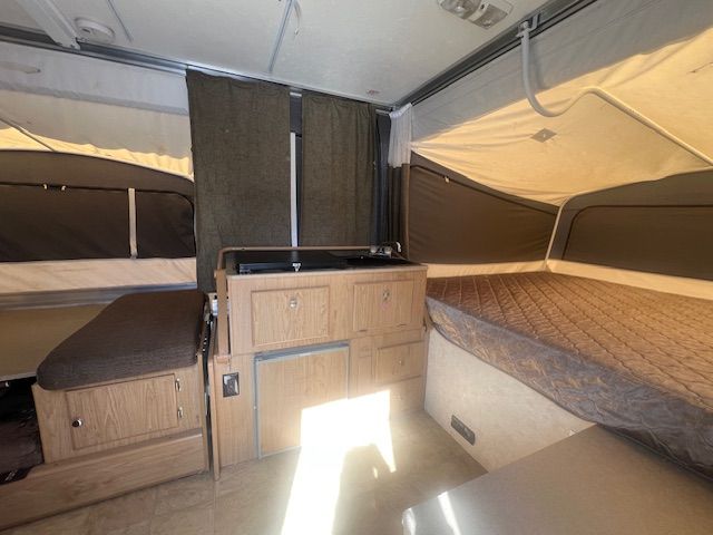 The inside of a camper with two beds and a kitchen