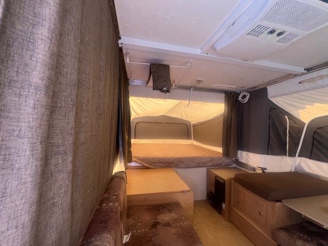 The inside of a camper with a bed and a couch.