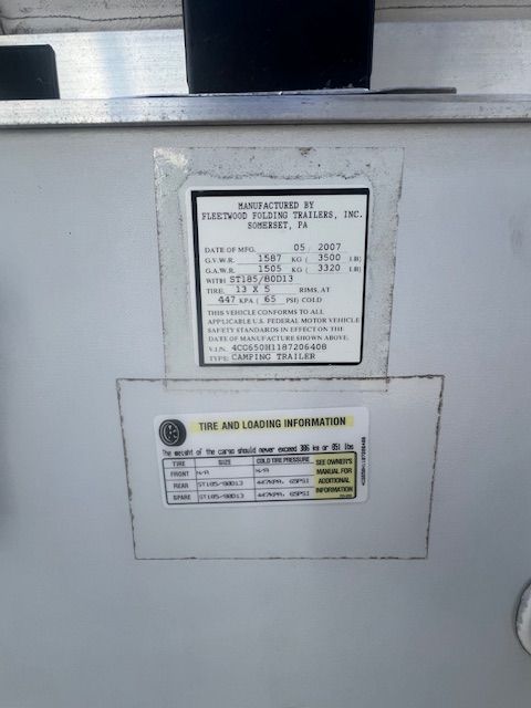 A white box with a sticker on it that says tire and loading information