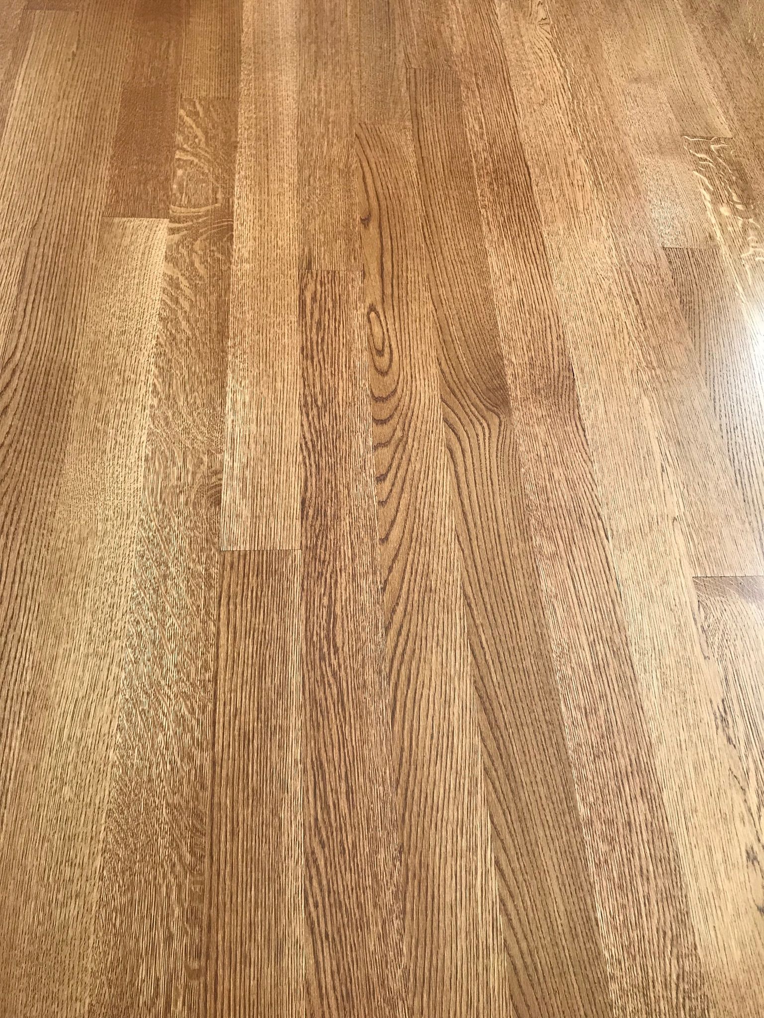 Wooden floor with a complex grain pattern in warm brown tones.