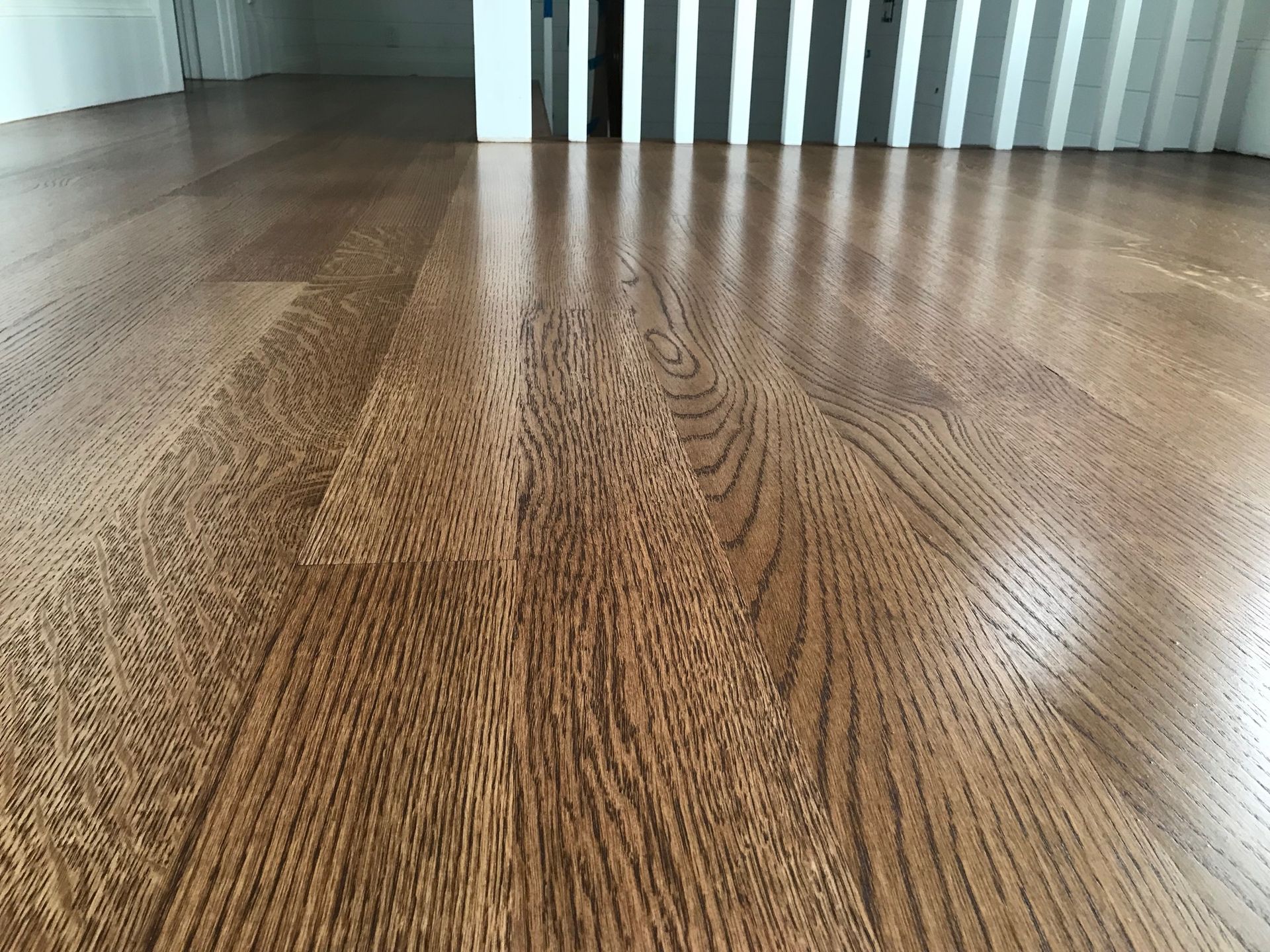Close-up of shiny, wooden hardwood floor with light reflecting off the surface.