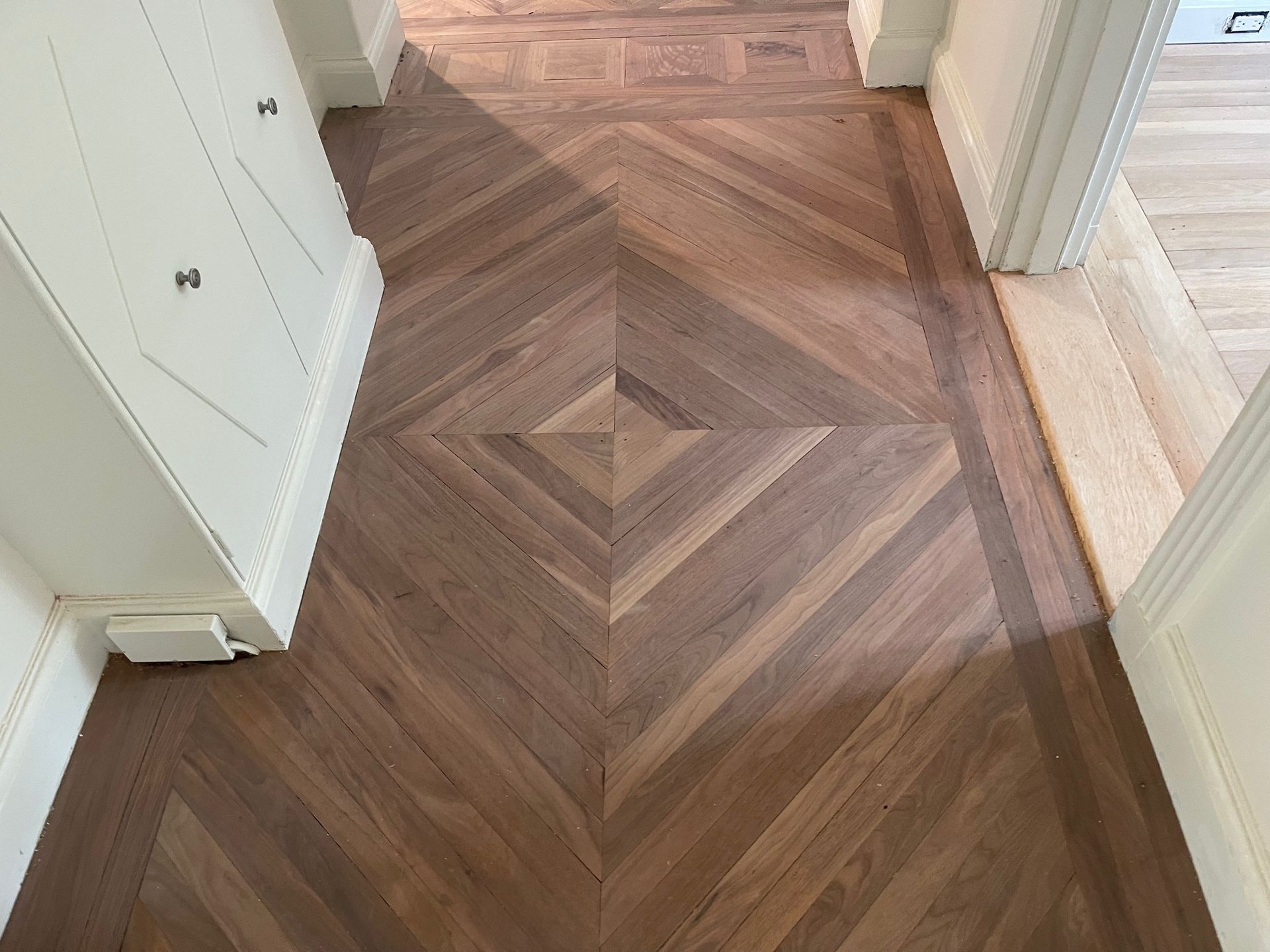 Wood parquet flooring in a geometric diamond pattern.