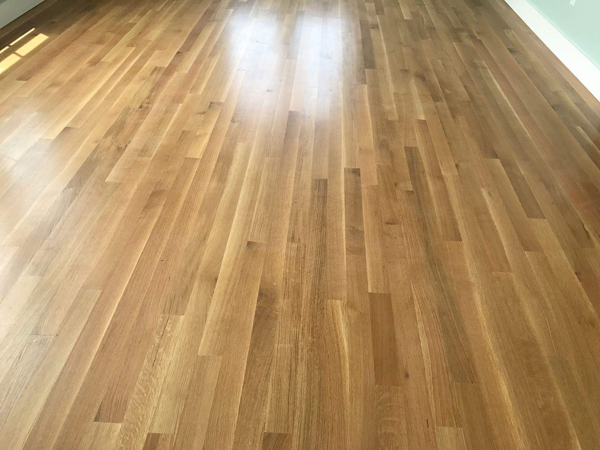 Wooden hardwood floor with long, light brown planks.