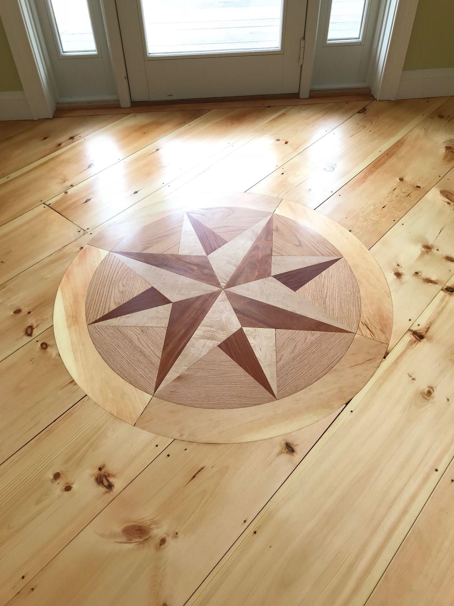 Wooden floor with inlaid nautical star design.