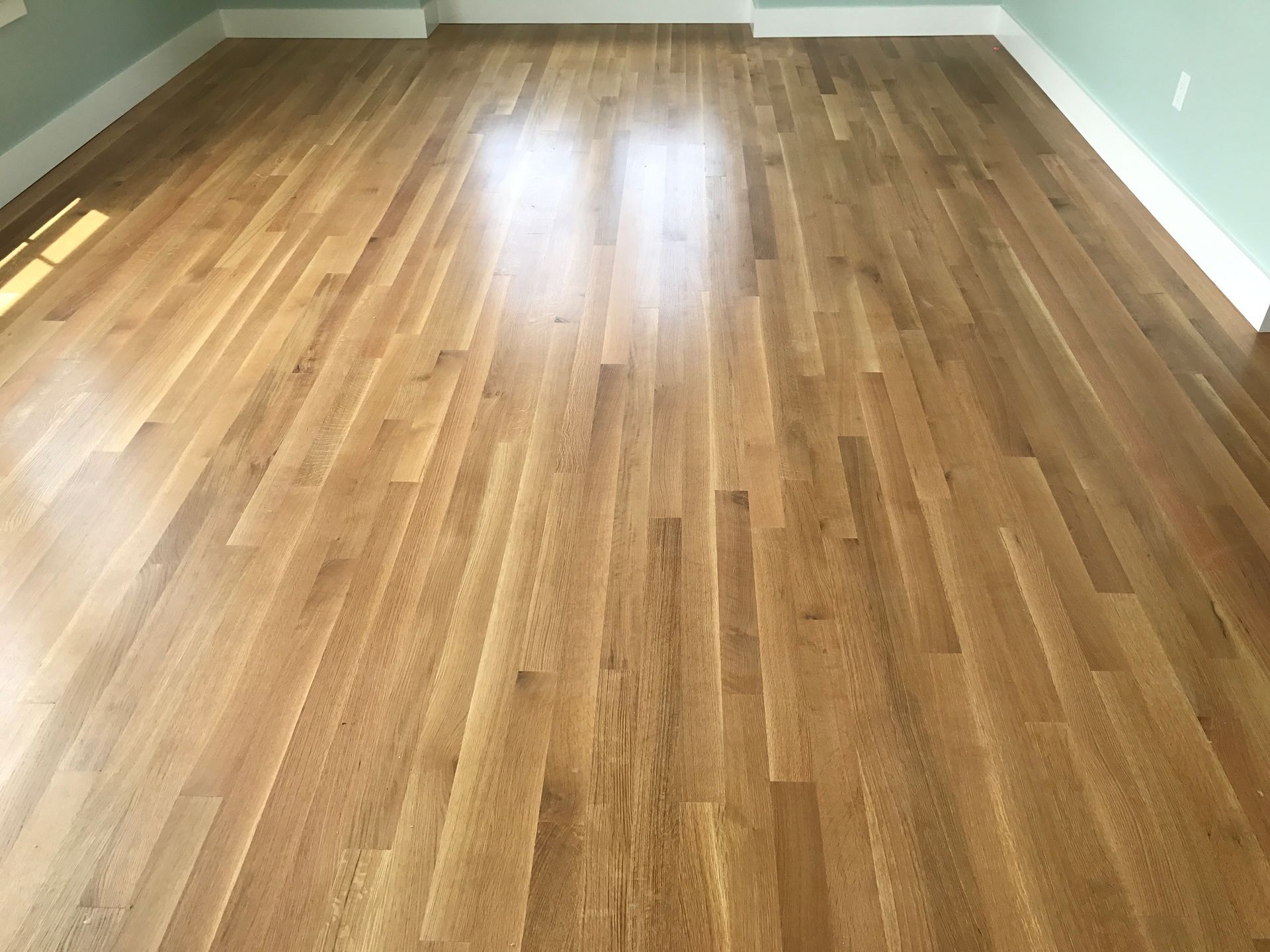 Wooden hardwood floor with light reflecting from the surface.