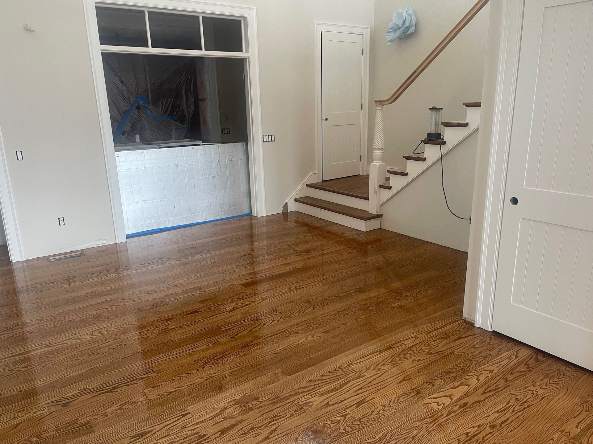 Hardwood floor interior with stairs and doors.
