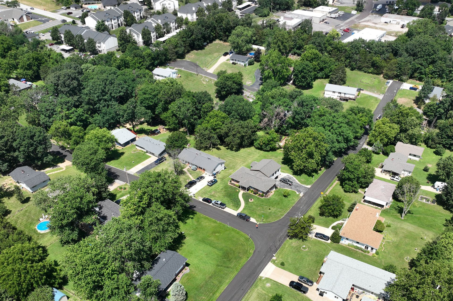 Aerial view of a suburban neighborhood with houses, trees, and curving streets.