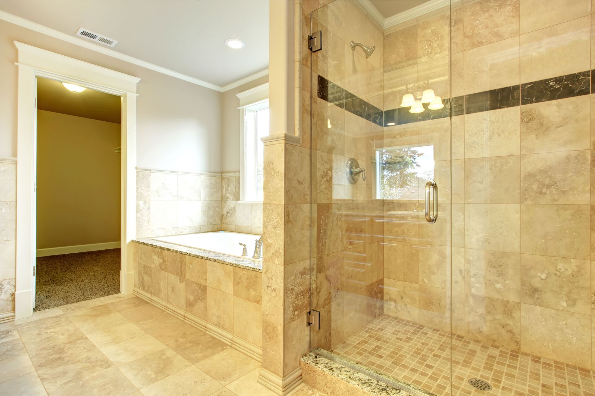Spacious beige marble bathroom with a soaking tub, glass shower, and double vanity area.