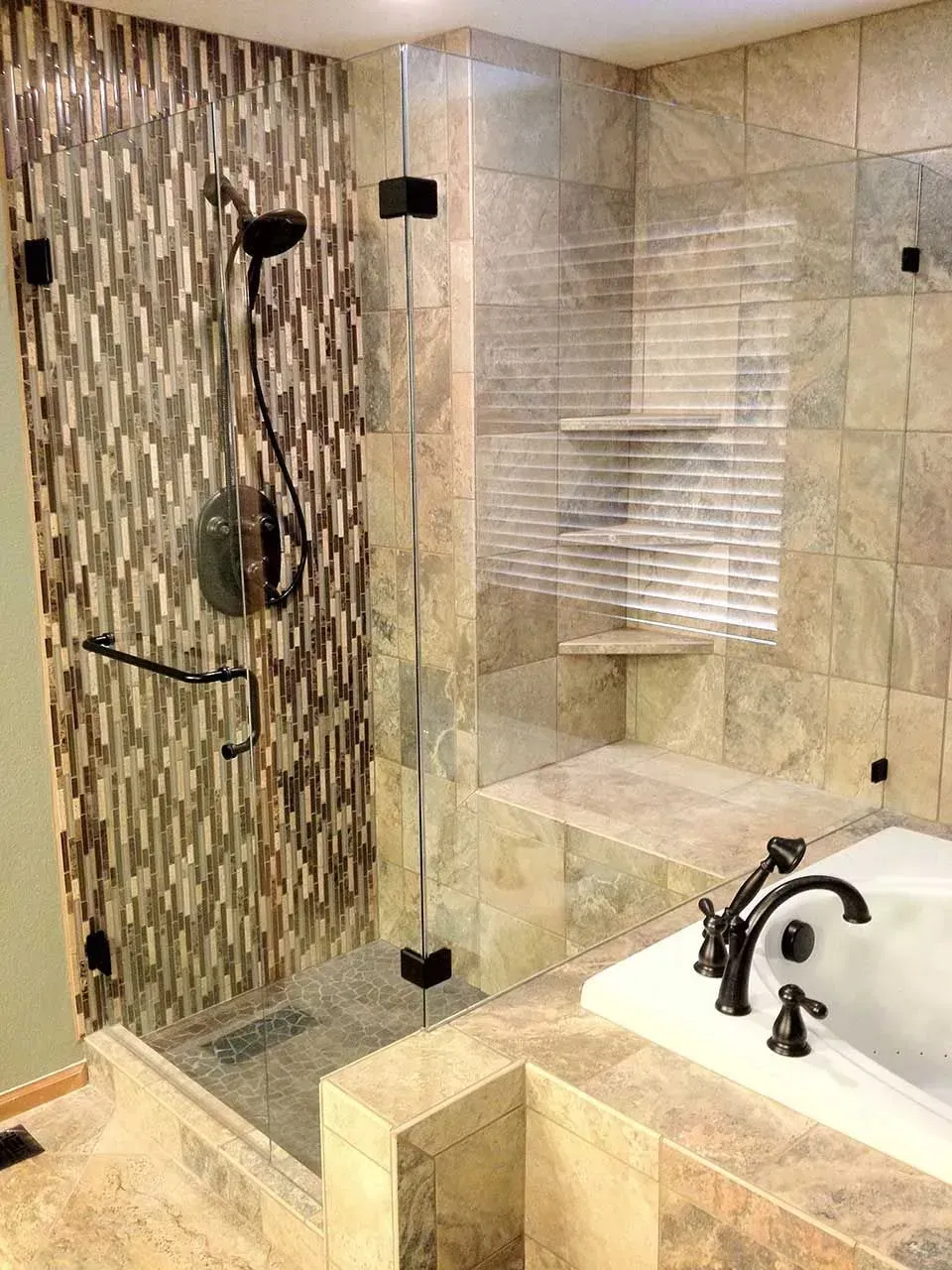 Modern bathroom with glass shower, stone tile walls, and a white sink countertop.