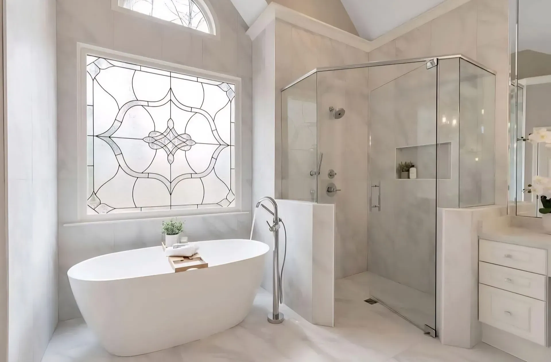 Bright white bathroom with freestanding tub, glass shower, and decorative stained-glass window.