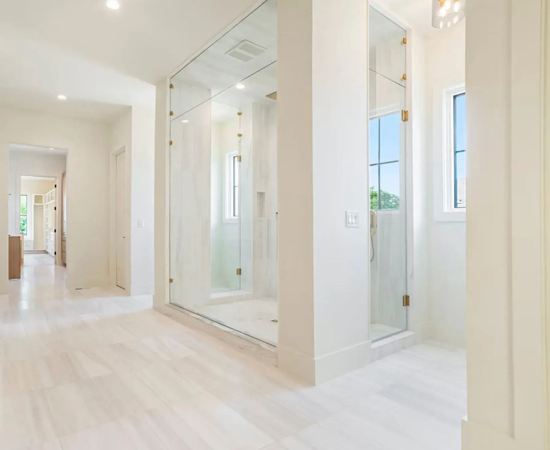 Bright modern hallway with white walls, light wood floors, and mirrored sliding closet doors