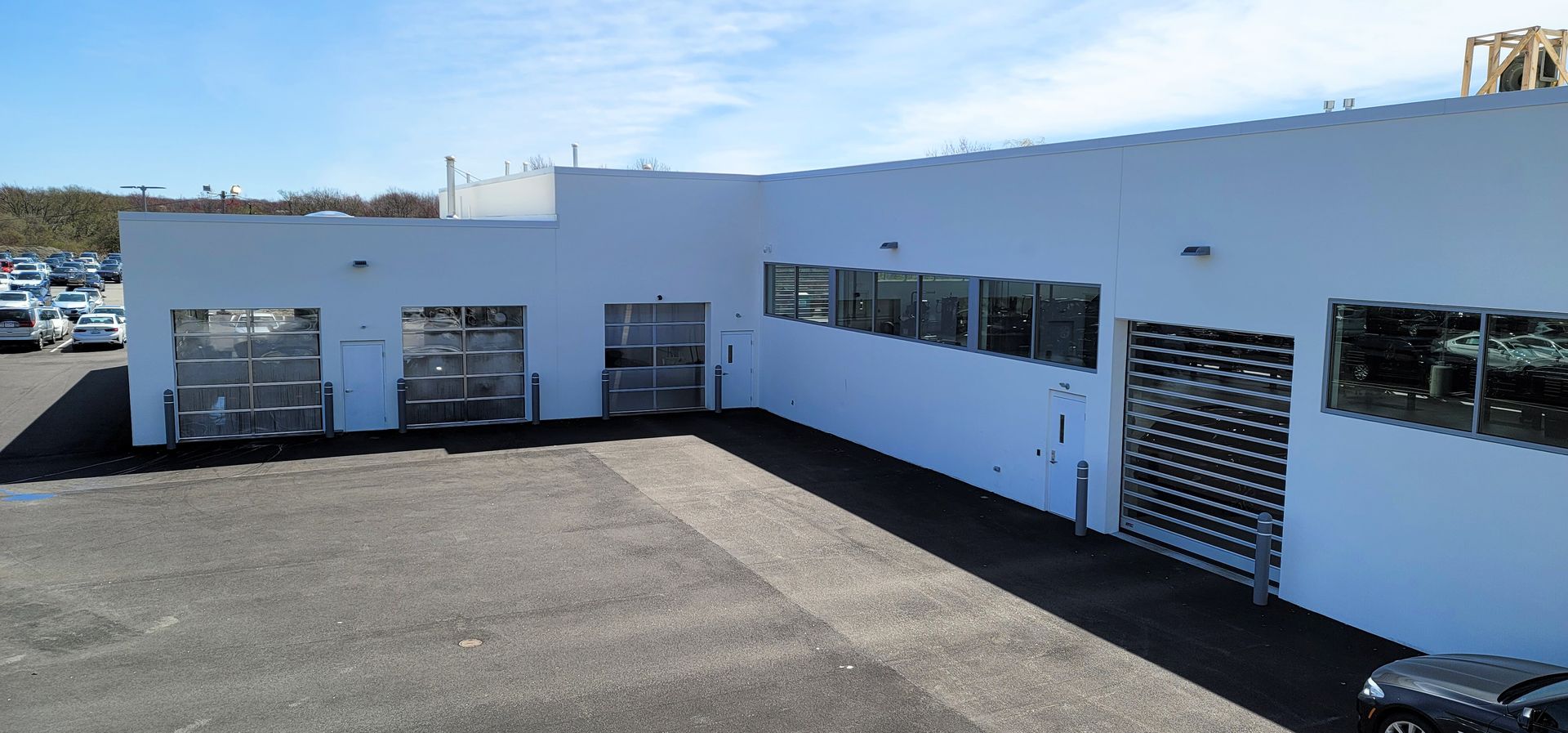 A white building with a car parked in front of it