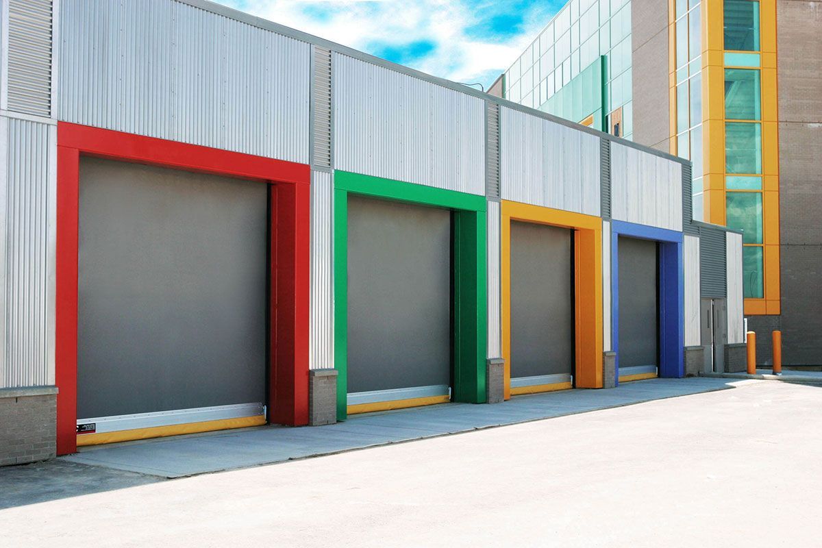 A row of colorful garage doors on the side of a building.