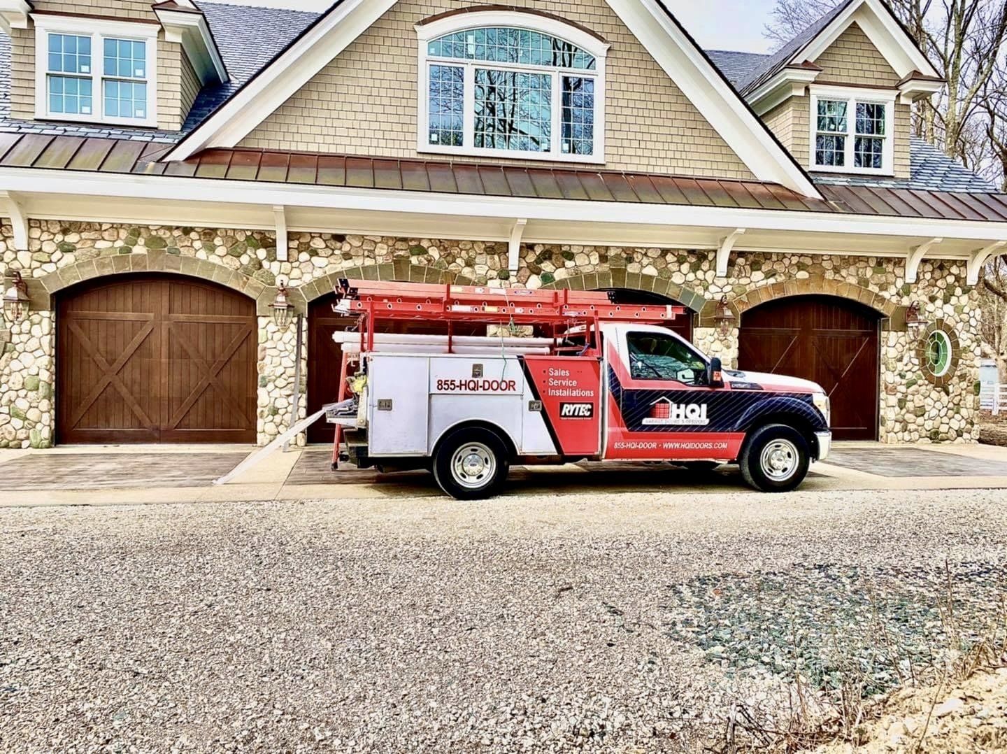 A truck is parked in front of a large stone house.