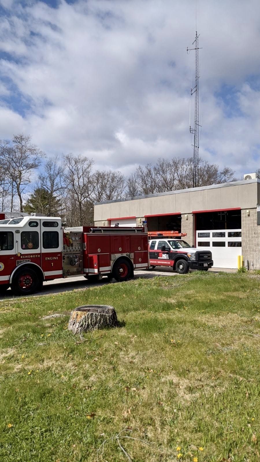 A fire truck is parked in front of a fire station.