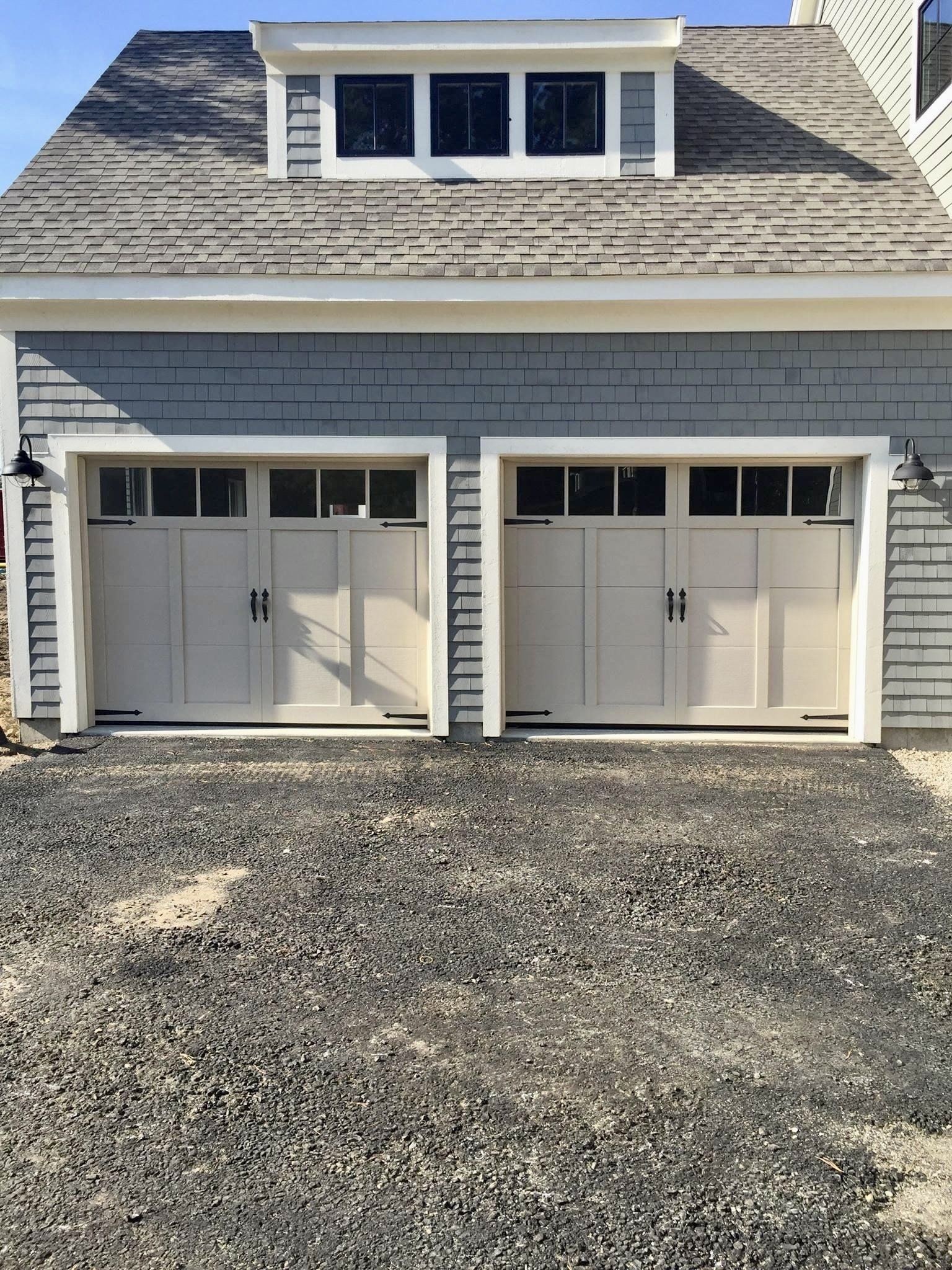 A garage with two white garage doors and a gray roof