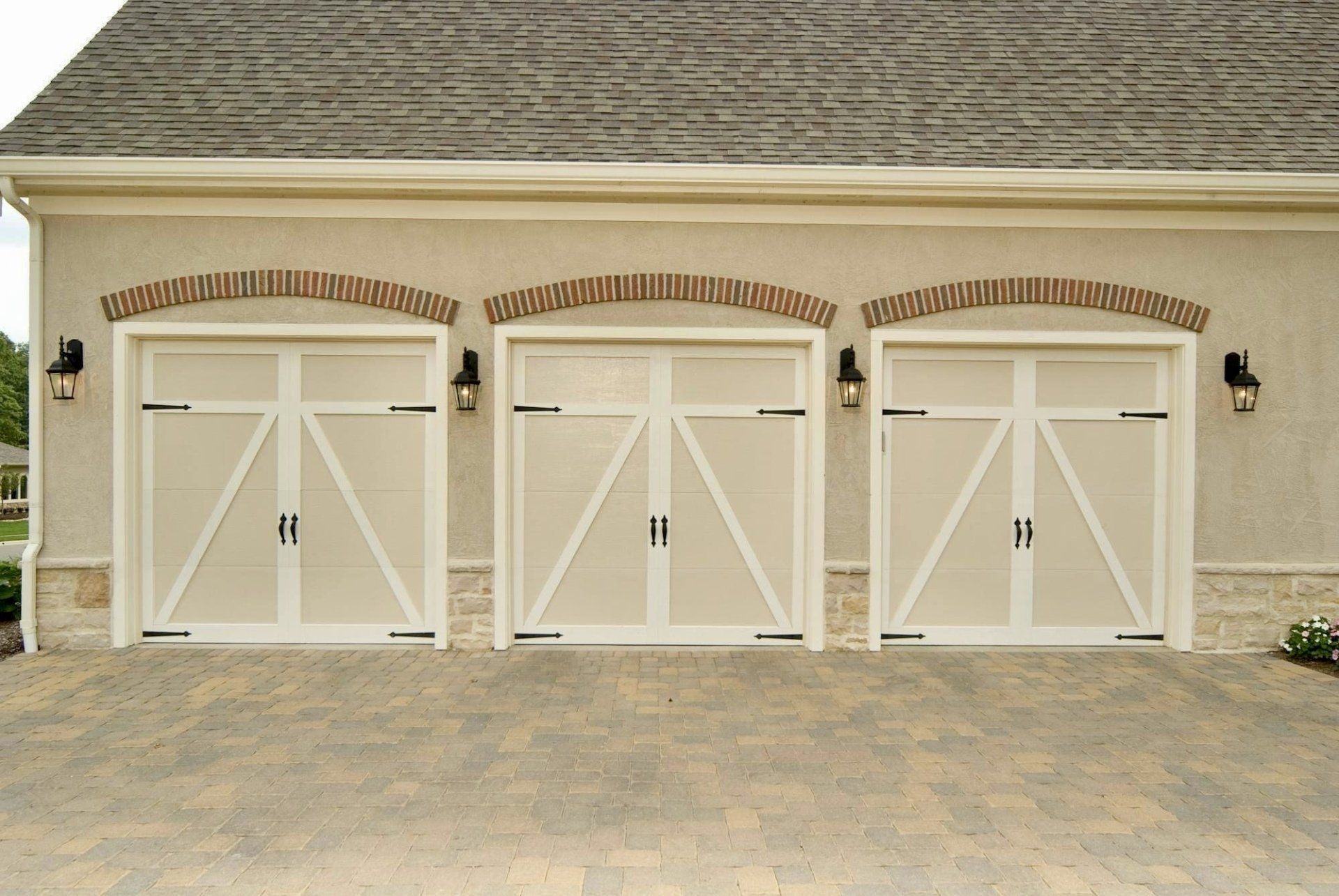 A row of white garage doors on a house