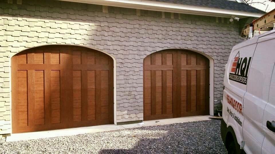 A white van is parked in front of a garage door.