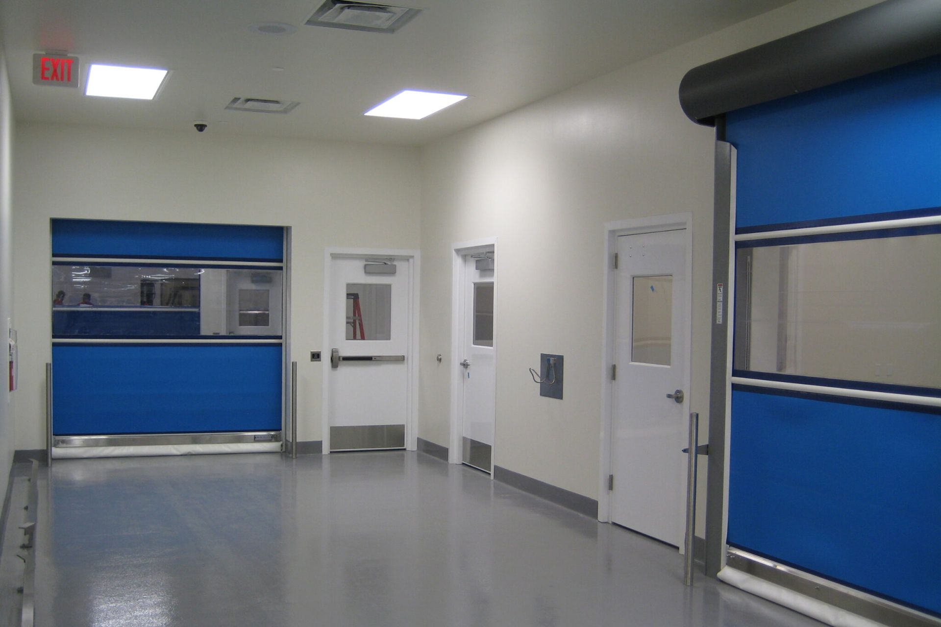 A hallway with blue doors and white doors