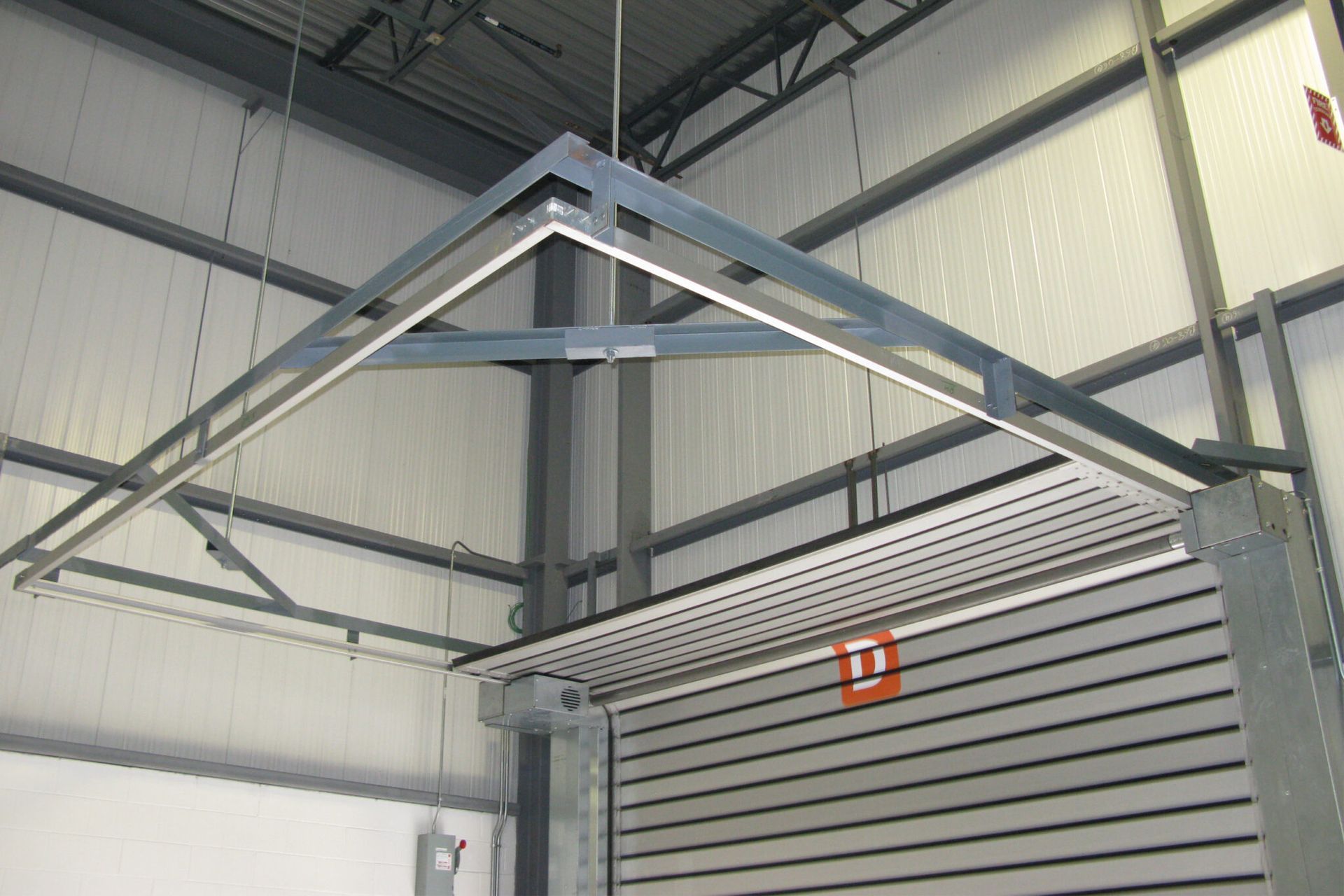 A metal structure is hanging from the ceiling of a building