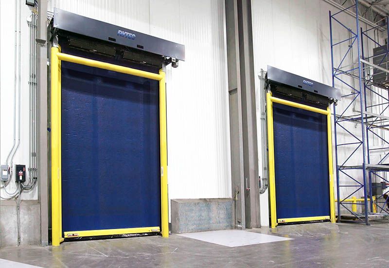 Two blue doors with yellow trim are in a warehouse.