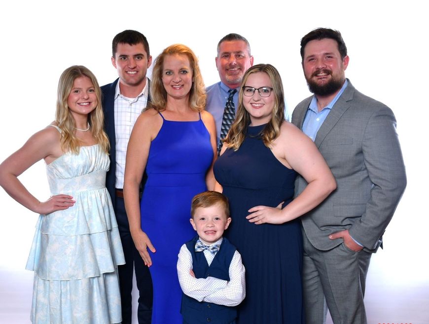 A group of people posing for a picture with one of them wearing a blue dress